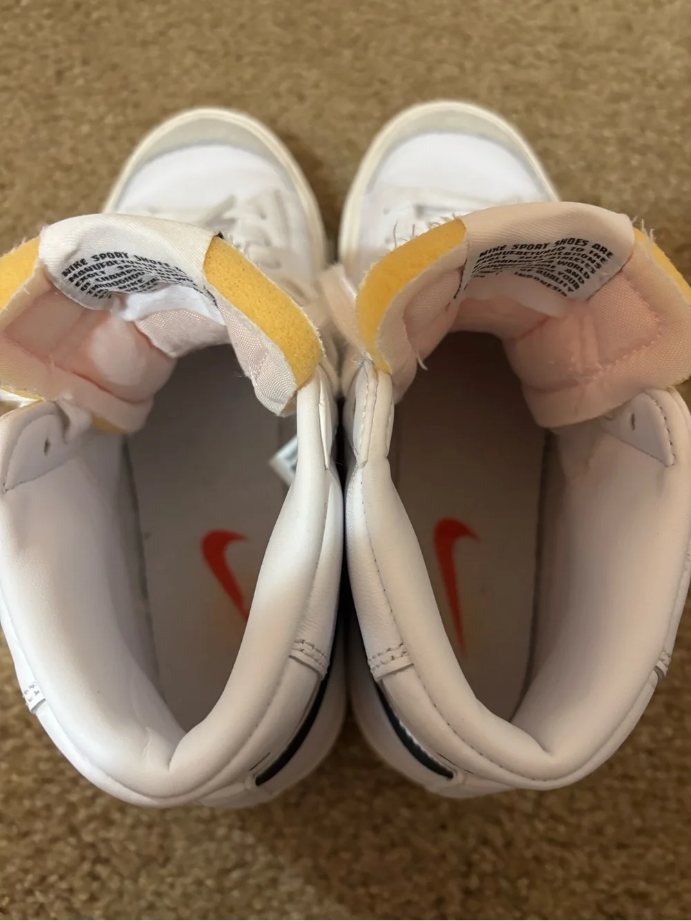 Nike White High-Top Sneakers with Black Swoosh and Yellow Tongue